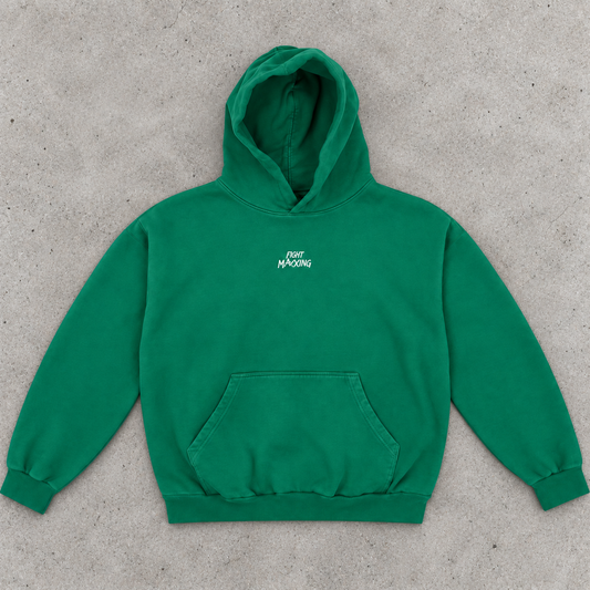 Fight Maxxing oversized hoodie in green, laid flat on grey cement