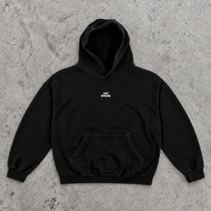 Fight Maxxing oversized hoodie in black, laid flat on grey cement