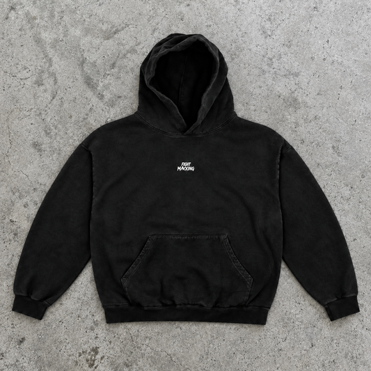 Fight Maxxing oversized hoodie in black, laid flat on grey cement