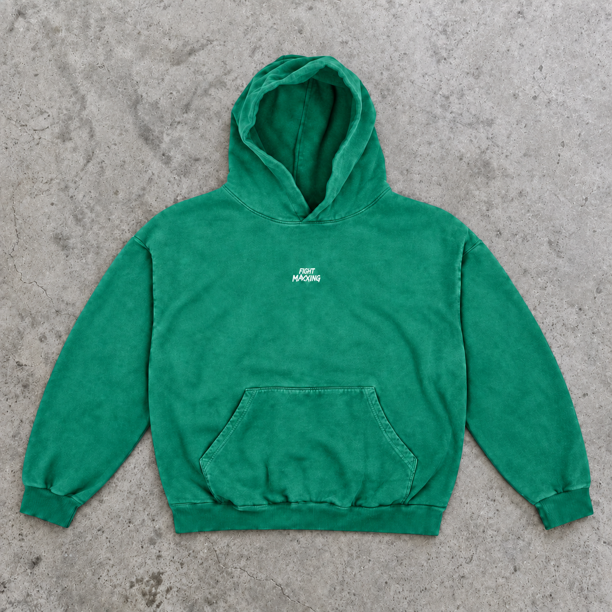 Fight Maxxing oversized hoodie in green, laid flat on grey cement